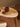 Wooden table with lovely curves with a red apple and rolled-up paper on a wooden floor.