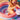 Child playing in a small inflatable pool with colorful toys.