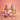 A stylized product render of two pink soft-ice cream swirls in yellow cones, displayed on a lavender stand with pink and yellow melting ice cream puddles and sprinkles on a peach background.