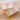 An open wooden box of Billes & Co. Unicorn themed marbles on a wooden tabletop, with the pink unicorn-patterned lid placed beside it and several loose marbles scattered around.