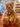 A plush teddy bear with light brown fur with glittery silver accents sits on a wooden table in a shop. The bear wears a beige scarf and has a brown hangtag attached to its neck. It is labelled Bear C.