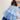 Close-up of a blue and white layered dress up with a neutral background