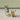 Toy mouse on a bicycle with a cart full of items against a plain background