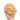 Hand holding a glittery gold stress ball with a face on a white background