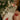 Decorative Christmas stocking with embroidered designs in front of a lit Christmas tree.