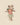 Stuffed mouse toy wearing a striped shirt and floral skirt on a beige background