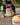 Child sitting on a stack of colorful Stapelstein blocks on a wooden deck.