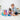 Two children playing with colorful translucent marble-run style blocks and tubes on a white rug in a bright indoor room.