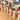 Children playing with wooden block towers on a wooden floor in a living room.