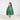 Child wearing a green tiered Christmas Tree cape with decorative elements on a white background