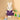 White crochet bunny toy in a purple dress with wooden blocks and toys on a wooden floor.