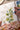 Person coloring a book with butterfly and flower designs using watercolor paints.