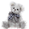 Fluffy teddy bear with a plaid bow tie on a white background