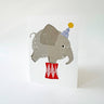 Illustration of an elephant wearing a party hat and red pants on a white background