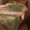 Children's bed with green blanket and matching star-shaped pillow