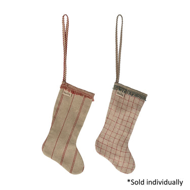 Two rustic fabric Christmas stockings hanging against a white background. One stocking is beige with red vertical stripes and a red braided hanging loop.