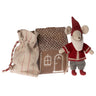 Small toy mouse in a red outfit with a house and bag on a white background
