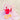 Pink bucket, yellow spade, and transparent beach bag on a striped towel with sand in the background