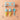 A silicone ice cream cone mold set on a peach background with scattered sprinkles. The set includes a light blue plastic cone holder, two light blue silicone swirl molds, two yellow waffle cones, and a light blue scoop with the brand name 'magic' printed on it.