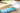 Set of colorful markers on a wooden surface with papers in the background