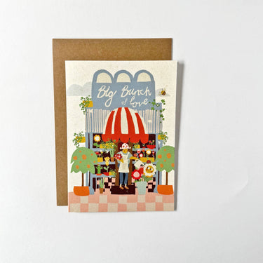 Greeting card with illustration of a flower shop and 'Big Bunch of Love' text on a white background.