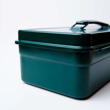 Green metal toolbox with a lid on a white background