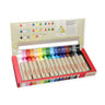 Kitpas crayon wax set in an open red box, showing multiple colored wax crayons in a row with a color chart printed inside the lid, on a white background.