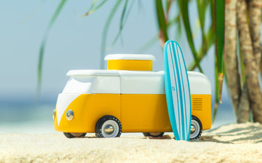 A wooden Volkswagen inspired Camper pop-top with a baby blue surfboard on a beach and palm tree scene.