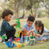 Children playing with 3D cardboard dinosaurs in a grassy park