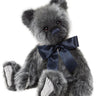 Gray teddy bear with a navy blue bow tie on a white background
