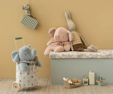 Children's room with plush toys including an elephant and a rabbit, and a small toy suitcase.