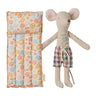 A stuffed mouse toy with tattoos and board shorts with a floral-patterned lilo on a white background