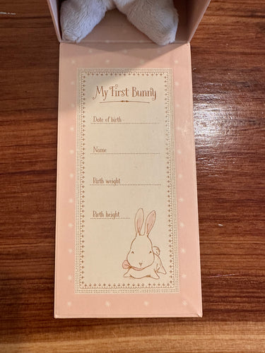 Baby milestone card with a bunny design on a wooden surface