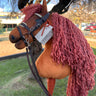 Plush hobby horse toy with pink hair and a hand made leather bridle