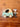 A cardboard toy car in mint green and beige with a small plush maileg mice doll dressed as a driver, placed on a warm brown wooden tabletop.