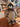 Stuffed raccoon toy with a plaid bow tie on a wooden surface