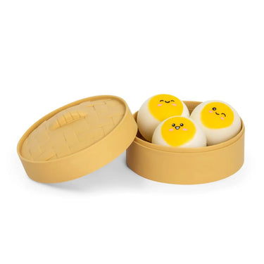 Plastic steamer style box with three round, cartoonish squishy dim sums on a white background