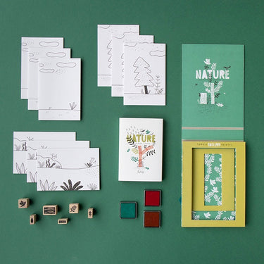 The components of the Londji Nature themed stamp kit including cards, stamps, and cardboard carry case on a green background