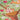 Illustration of three chicks in a nest with a mama bird flying in with some food on a green leafy background