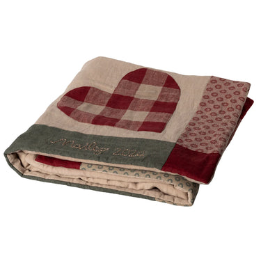 Folded blanket with a heart design and 'Maileg 2024" branding on a white background