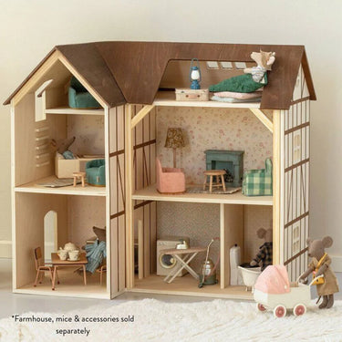 Wooden Maileg dollhouse with furniture and accessories on a light background