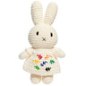 Crocheted bunny toy with colorful flower patterns on a white background