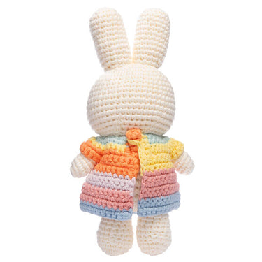 Crocheted toy rabbit with a colorful striped sweater on a white background
