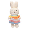 Crocheted bunny toy with a colorful dress on a white background