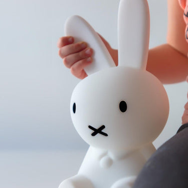White rabbit-shaped night light held by a person against a plain background
