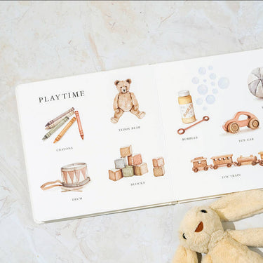 Children's book called Our Big Books of Words with illustrations of toys on a marble surface
