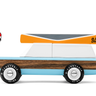 A toy car with wood trim, pale blue stripes and a toy canoe on its roof, on a white background
