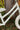 A close-up of a children's bicycle frame in off-white with small gold star patterns and the brand name 'Zalane' printed on the down tube, set against a natural background of a tree trunk and green foliage.