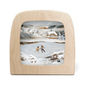 Wooden picture frame with a winter scene painting of two people skating on ice.