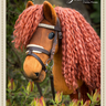 Plush toy horse with a braided mane standing among flowers, branded 'Summit Hobby Horses'.
